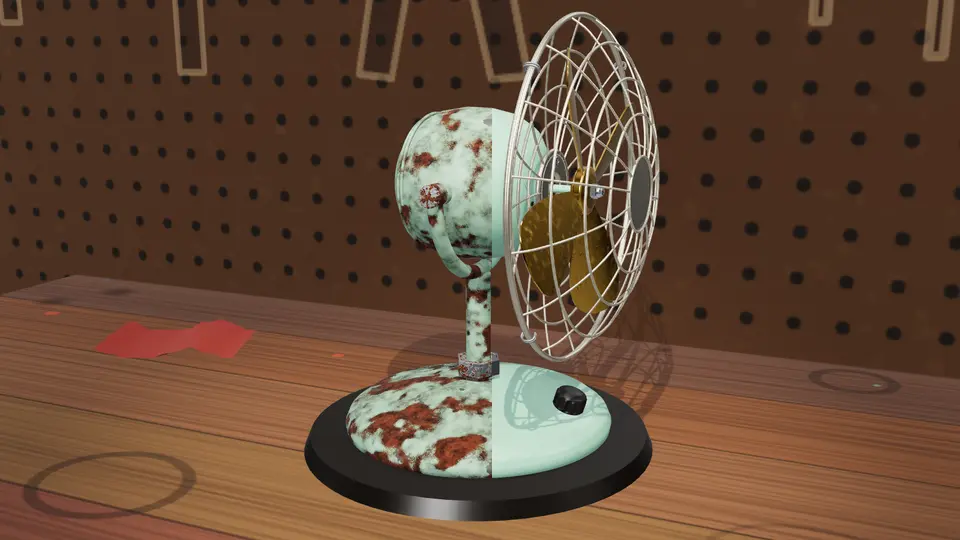 A 1950s desk fan on the workbench in Patinook, its left half still rusty, its right half restored.